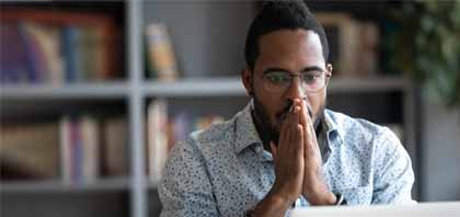 Homem pensativo em frente a uma tela de computador